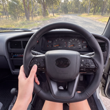 PVS steering wheel fitted in a Toyota Hilux LN106, driver's view down a gravel road
