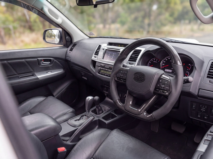 Toyota Hilux N70 fitted with the PVS 300 Series style steering wheel upgrade kit in traditional carbon with black leather