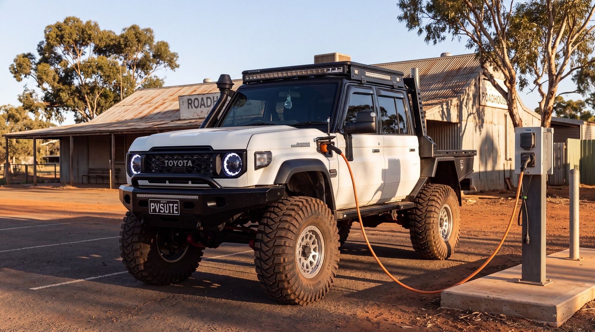 A plug-in hybrid dual cab ute charging at a rural Australian roadhouse