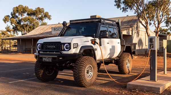 A plug-in hybrid dual cab ute charging at a rural Australian roadhouse