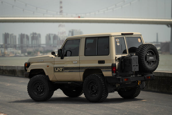 Sand LandCruiser 71 Series short wheelbase three-door, rear three-quarter view showing the single side window, barn door and rear-mounted spare