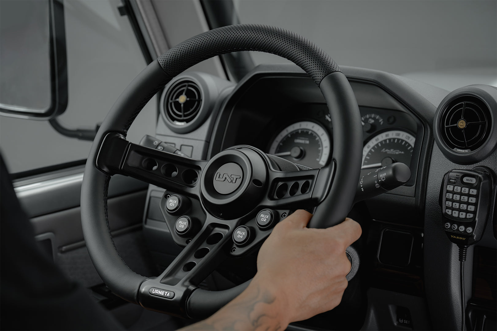 Driver holding an ADR-compliant aftermarket steering wheel in a Toyota LandCruiser 70 Series