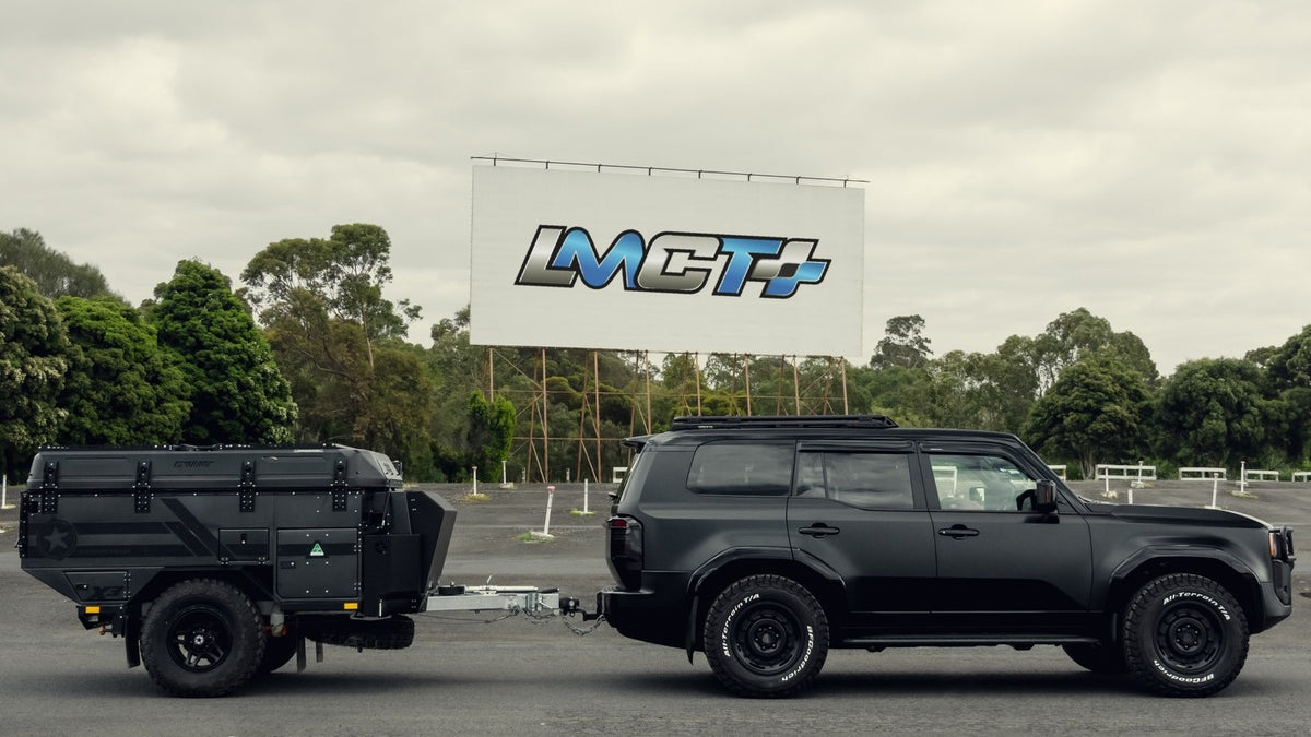 Toyota LandCruiser 250 Prado built by PVS Automotive with camper trailer in front of the LMCT+ billboard